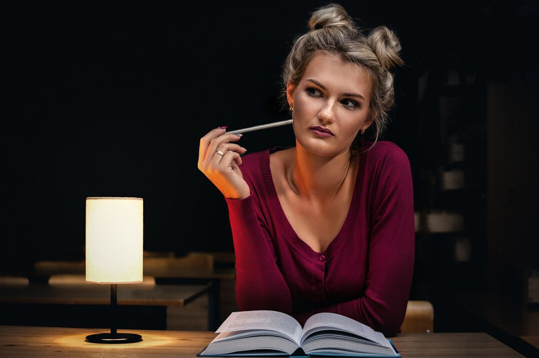 woman reading mystery book at night